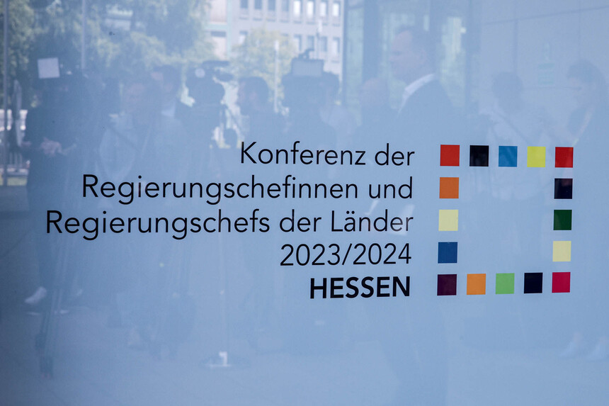 Auf einer Eingangstür ist ein Logo der Ministerpräsidentenkonferenz angebracht.