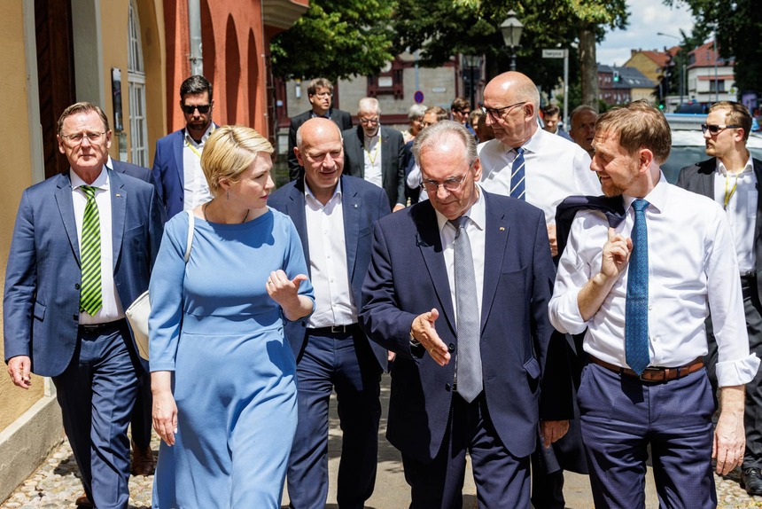 Männer und Frauen laufen nebeneinander durch eine Fußgängerpassage.